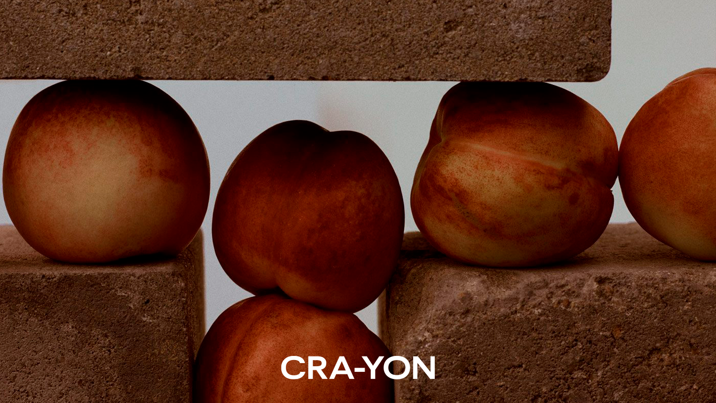 Peaches arranged between textured bricks with CRA-YON logo below – natural fruit-inspired fragrance visual