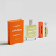 CRA-YON Passport Amour – two perfume bottles and orange boxes shot from the side on a light background